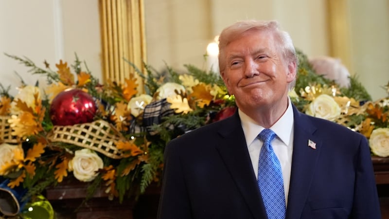 President Donald Trump smiles during a Hanukkah reception in the East Room of the White House,...